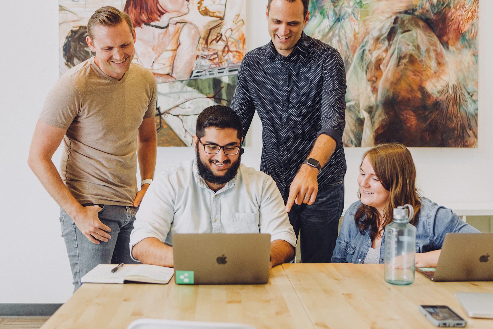 A small team working together around a laptop.